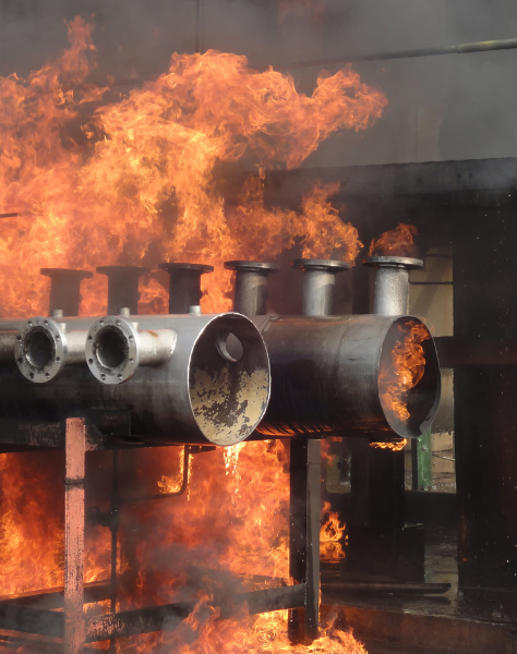 A fire engulfs a set of industrial pipes
