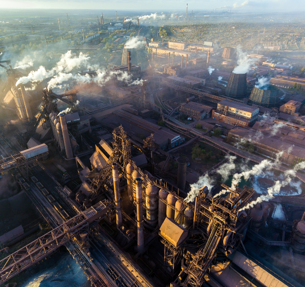 An aerial view of vapor coming off smokestacks at a large industrial plant
