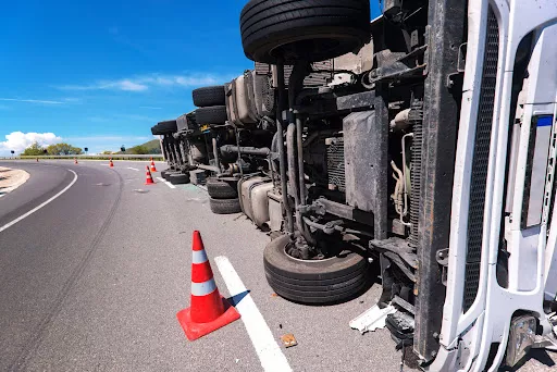 A semi truck tipped over on its side in the road