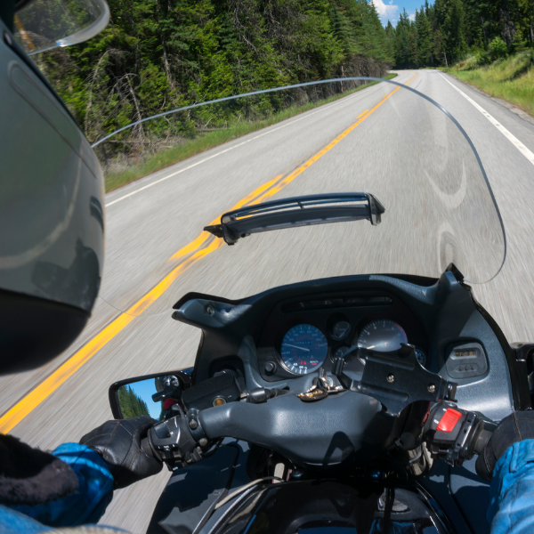 A person rides their motorcycle down a winding road in Louisiana