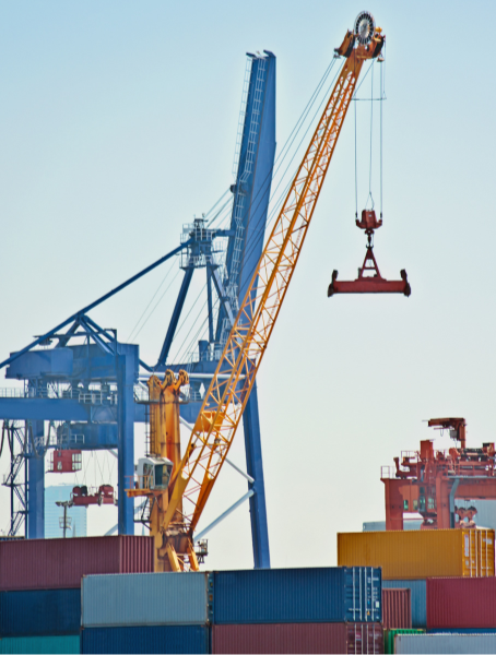 A crane moving multi-colored shipping containers on a dock