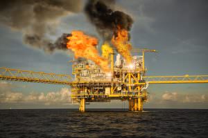 A burning oil rig at sea after an explosion.
