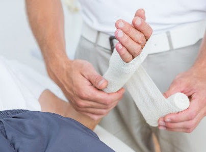 a doctor wraps a patient's hand after suffering a burn injury.