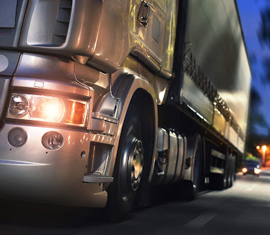 Close up of the left front end of a large truck at night