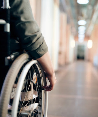 Man's arm touching a wheelchair tire in a hallway in Shreveport.