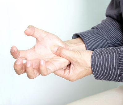 A person experiencing symptoms of paralysis in their hand, clutching their palm