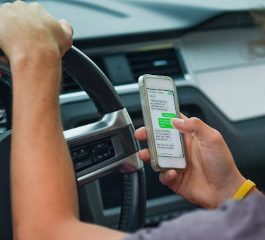 Displaying distracted driving behavior, a  man texts while driving in Louisiana.