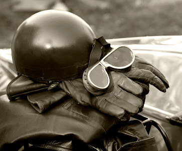 Goggles, gloves, and a motorcycle helmet sitting in a pile
