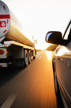 A tanker truck speeds past a car on a Louisiana road