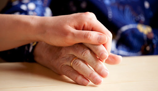 A young hand comforting an old hand after a loved one's wrongful death.