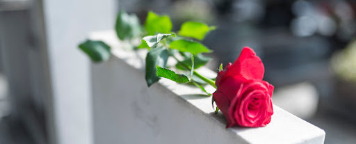 A single red rose laid on the tombstone of a wrongful death victim in Lake Charles.