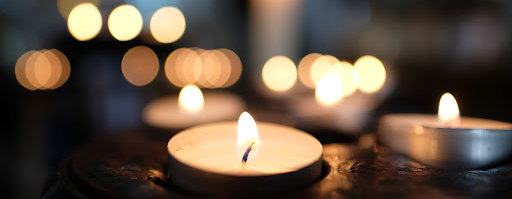 A closeup picture of tealights, a symbol of remembering lost loved ones.