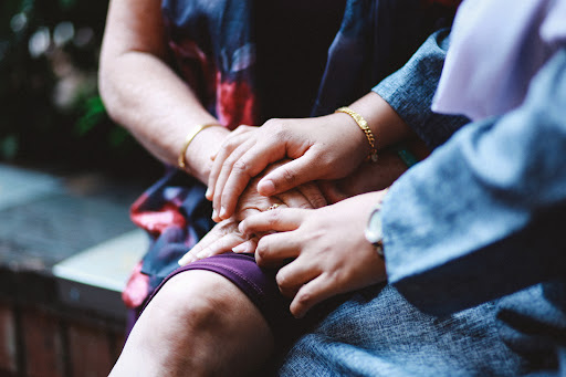 Two women sitting and comforting each other at the funeral of a loved one.