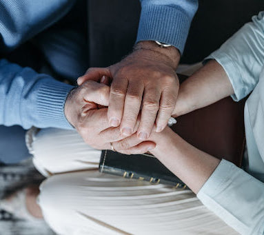 A couple holds hands, consoling each other after the wrongful death of a loved one.