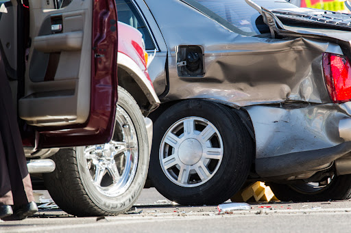 A closeup of damage to the rear end of a car after an accident.