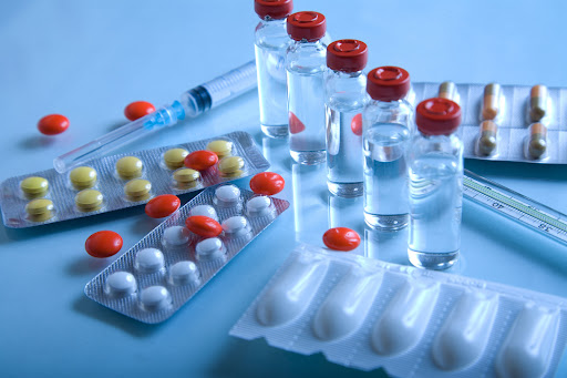 An assortment of defective pharmaceuticals, including pills, vials, and syringes.