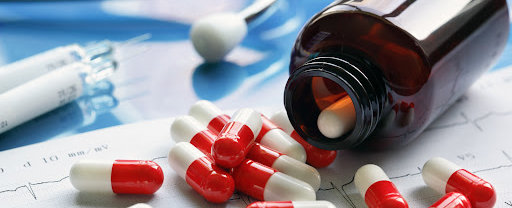 A bottle of defective drugs spilled on a medical readout.