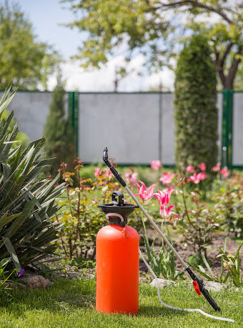 An orange weedkiller sprayer sits in a residential Louisiana lawn, potentially filled with the toxic substance Paraquat.