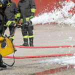 bombero extinguiendo con espuma el coche tras accidente de tráfico