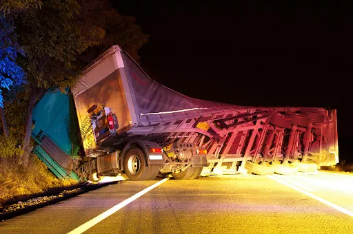 An overturned semi-truck on I-10 in Louisiana at night.