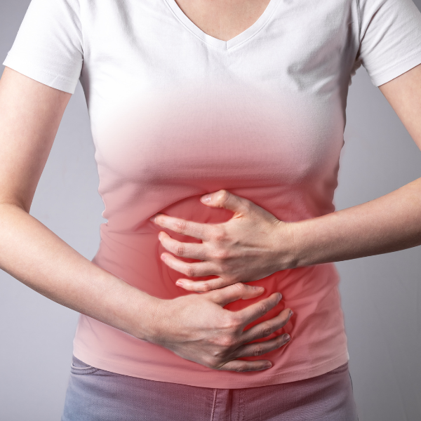 A person holds their stomach in discomfort.