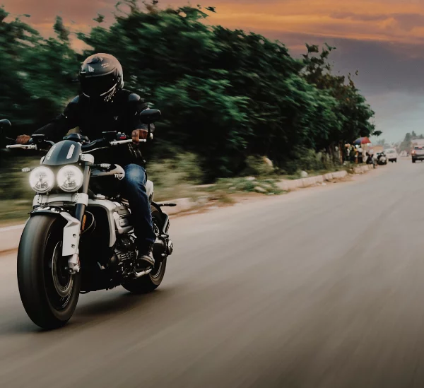 A motorcycle rider travels down a street in Zachary