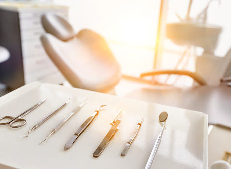 A dentist's chair with dental implements in the foreground