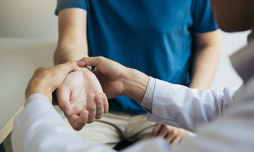 A doctor checks a patient's wrist for pain.