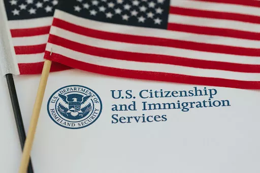 Two American flags resting on immigration papers