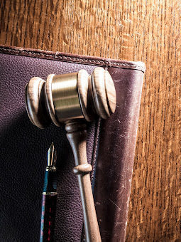 A lawyers gavel, pen, and notebook on a desk