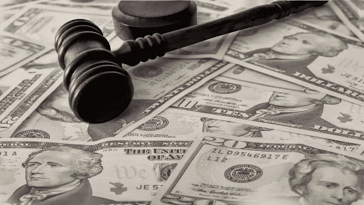 A wooden judge's gavel on top of cash