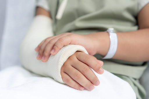 A child with a cast on their injured arm, closeup