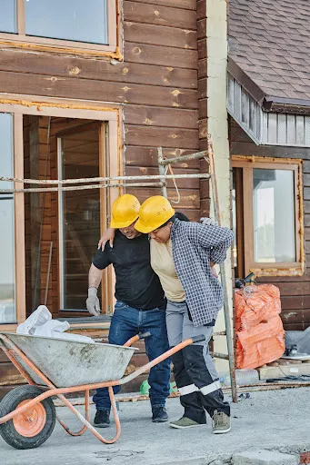 A construction worker being helped to walk after an injury on the job