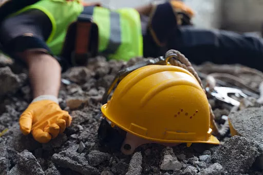 Un trabajador de la construcción tendido sobre un montón de escombros tras un accidente laboral