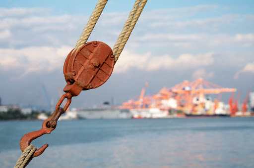 Maritime hardware and rigging with a shipping dock in the background