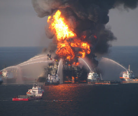 An offshore oil rig burning as fire boats fight the blaze