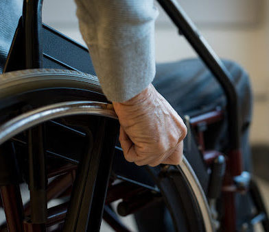 A paralyzed person in Baton Rouge holds the wheel of their wheelchair