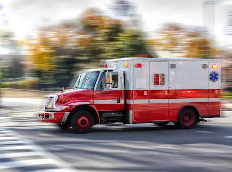 Photo of an red ambulance at a city street. Blurred motion. Urgency. Emergency
