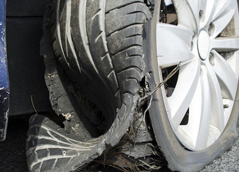 A severely blown-out tire on a car