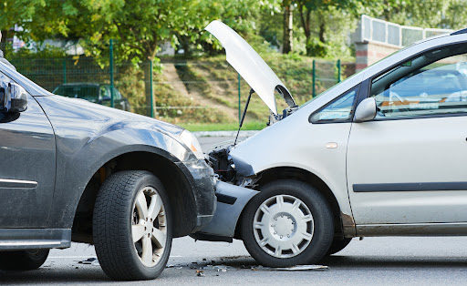 Two damaged vehicles in the middle of the street after a car accident