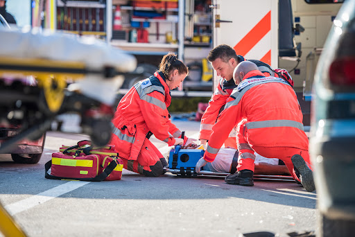 Paramedics treat the catastrophic injuries suffered by an injured man after a car accident