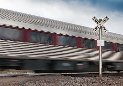 Coche de pasajeros vuela por cruce de ferrocarril - desenfoque de movimiento