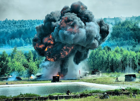 A large plume of smoke rises from a controlled explosion