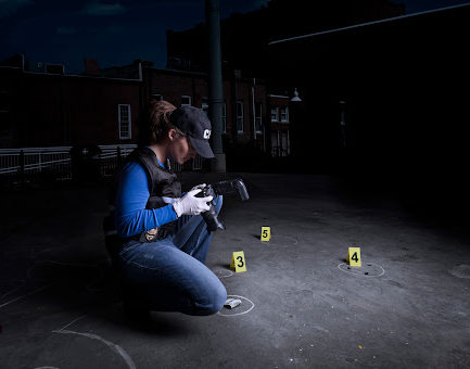 A crime scene photographer taking pictures of evidence 