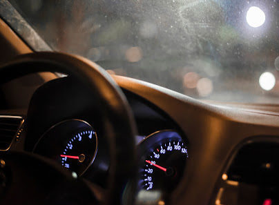 The dashboard of a car with lights on at night