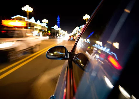 A car driving through a city in Louisiana at night