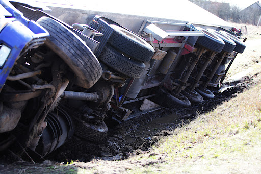 The underside of an overturned truck on the side of the highway