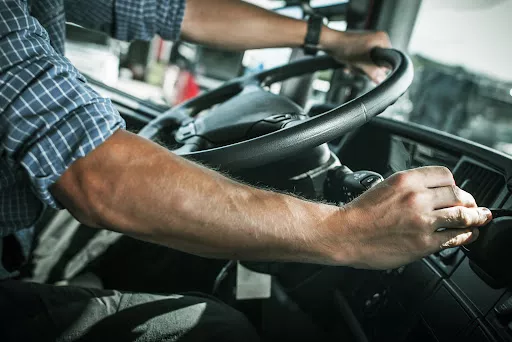 Caucasian Truck Driver Behind the Wheel of Semi Truck Transportation Industry