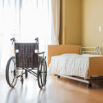 nursing home neglect image with empty wheelchair facing bed