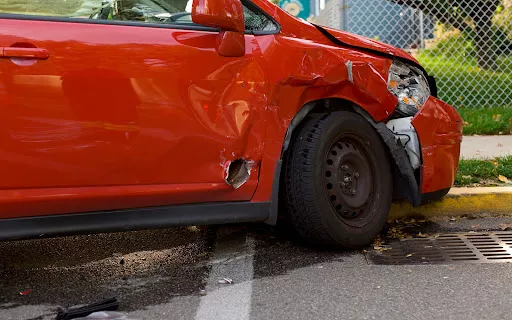 Damage to the side of a red car after an accident in Lake Charles